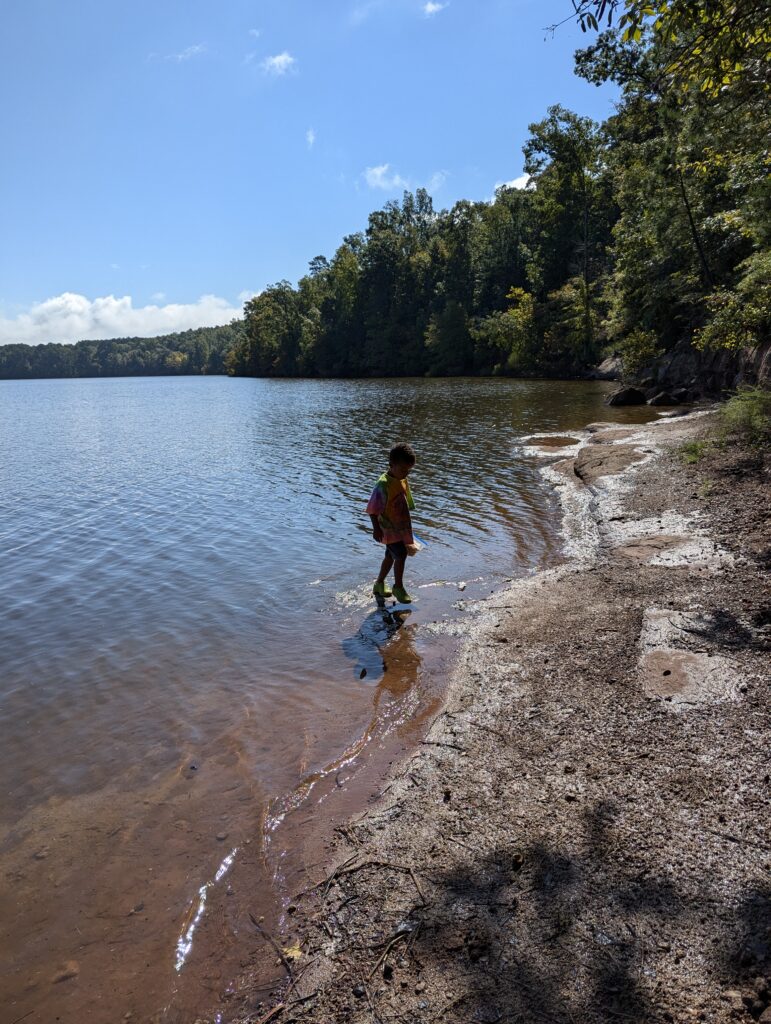 Child on lake shore at campground