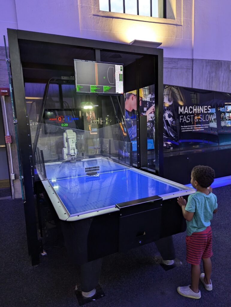 Child playing with robot at science center